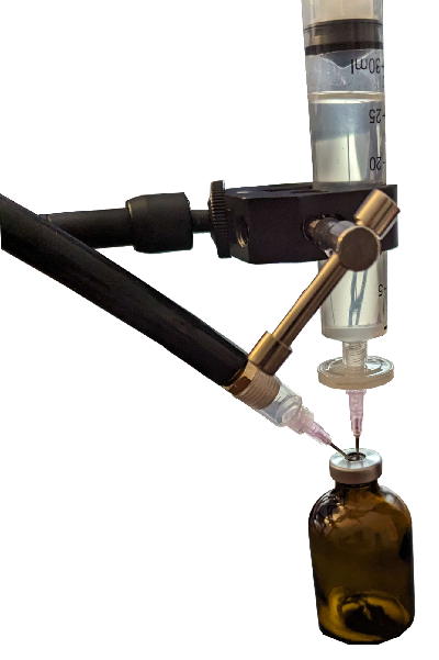 A photo of a vial with a syringe filter inserted into a vial and another needle connected to the vacuum inserted into the vial.